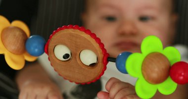 Baby seated in chair with toy in foreground