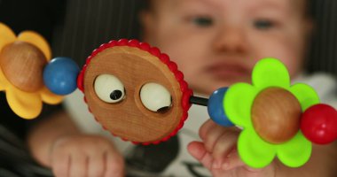 Baby seated in chair with toy in foreground