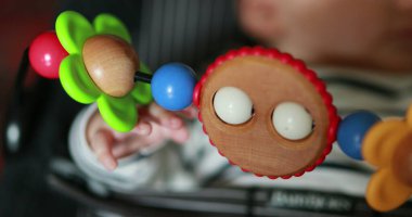 Baby infant newborn seated in baby chair rocker with toys