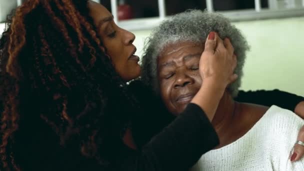アフリカ系アメリカ人の大人の娘が額に80代のシニアマザーにキスし カメラで笑顔を浮かべる — ストック動画