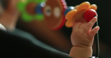 Closeup of infant baby hands playing with spinning toy