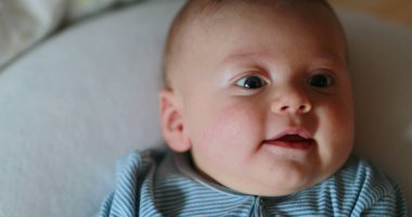 Happy baby portrait face looking to camera smiling and laughing