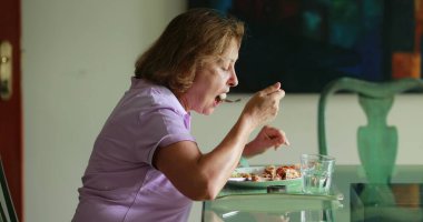 Candid older woman eating lunch authentic real life