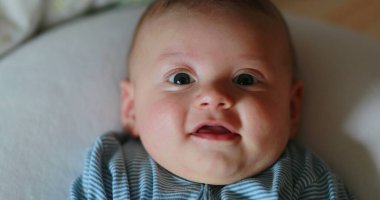 Happy baby portrait face looking to camera smiling and laughing