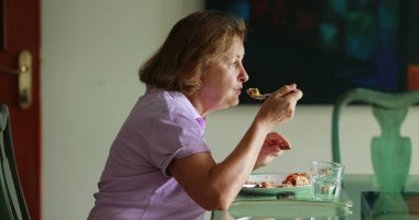 Candid older woman eating lunch authentic real life