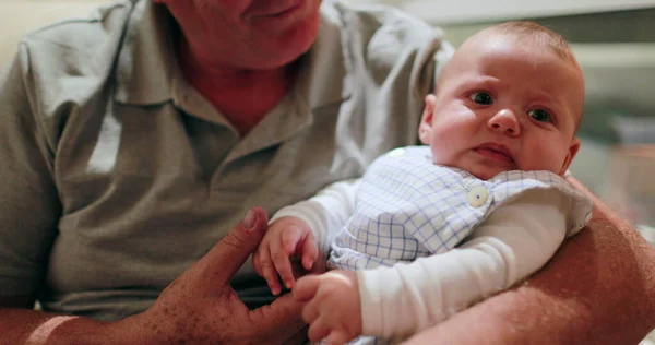 Grand-father holding grand-son baby infant in arms casual