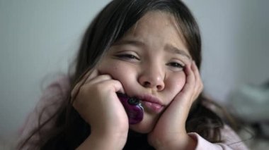 Kadın çocuğun yakın plan yüzü. Yorgunluk ve bıkkınlık hisseden, başı havada yorgun bir çocuk. Uzağa bakan, düşüncelere dalmış bir çocuk.