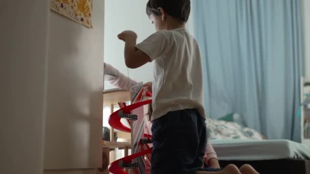 小男孩在卧室的地板上玩停车场结构玩具 晚上睡觉前在家里玩耍的孩子 童年的休闲活动 — 图库视频影像