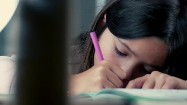 ペンを着色するペン 芸術的な遊びに従事する少女のタイトなクローズアップの顔の紙に集中した子供 — ストック動画
