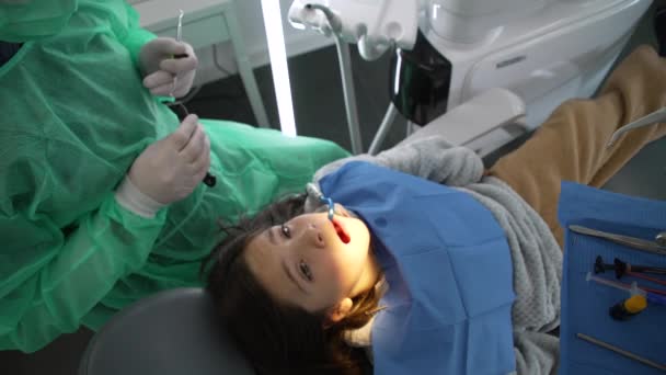 Mała Dziewczynka Siedząca Gabinecie Dentystycznym Przed Zabiegiem Zębów Lekarz Przygotowuje — Wideo stockowe