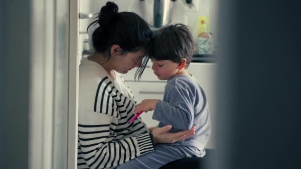 キッチンで柔らかい本物の愛情シーンで傷ついた後 暖かい抱擁を世話する子供の誤った行動を説明する候補の母親 親の指導 — ストック動画