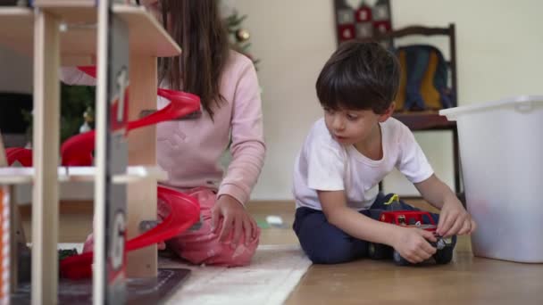 Geconcentreerde Jongen Spelen Met Zijn Vrachtwagen Speelgoed Naast Zus Broer — Stockvideo