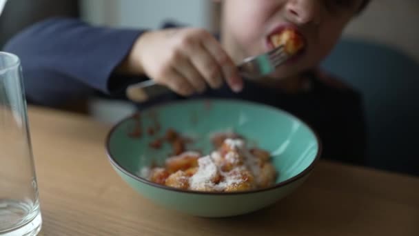 소년은 접시에 녹치를 먹습니다 음식을 즐기는 포크를 펜시브 아이의 클로즈업 — 비디오