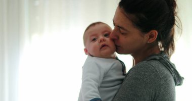 Mom consoling baby infant in causal candid authentic moment