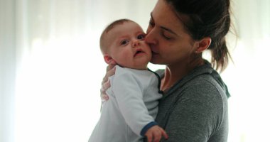 Mom consoling baby infant in causal candid authentic moment