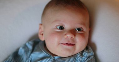 Joyful happy newborn baby smiling and laughing face expression