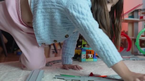Seorang Gadis Kecil Bermain Dengan Mainan Kereta Api Lantai Rumah — Stok Video