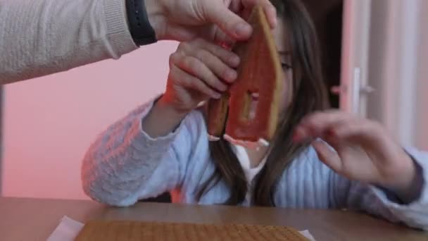 Маленькая Девочка Помещает Кусочек Пряничного Домика Крупный План Ребенка Занимающегося — стоковое видео
