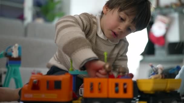 游戏中的聚焦儿童 幼儿小心地把玩具装在火车车厢里 展示精细的运动技巧和嬉闹的想象 — 图库视频影像