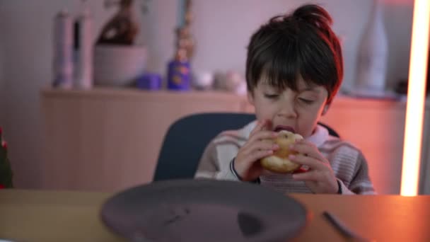 1人の少年がテーブルに座ったパンを食べる カーボンフードを噛む子供 — ストック動画