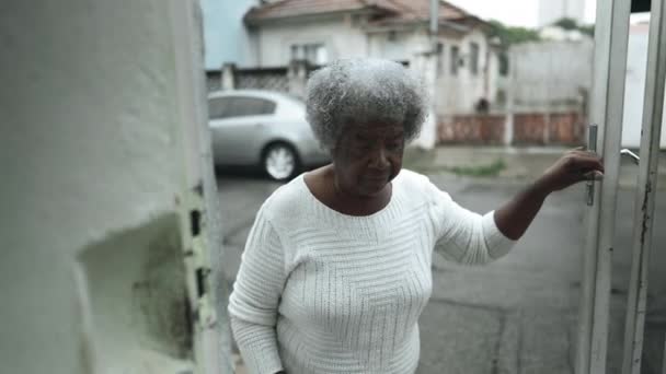 一位年长的黑人女士从城市人行道上打开住宅前门 爬上楼梯回家 卑微的老年非洲裔美国妇女到达居住地 — 图库视频影像