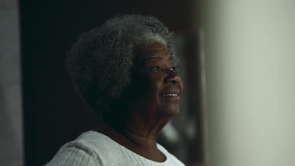 一位80多岁的快乐沉思的老年黑人女士从住宅窗口凝视着 Candid Thoughtful高级非洲裔美国妇女 — 图库视频影像