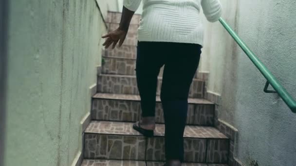 坐在矮小 活泼的非洲裔美国老年妇女后面 站在楼梯上来到南美洲的住宅时 手里拿着金属棒 站在墙上 怒吼着 — 图库视频影像