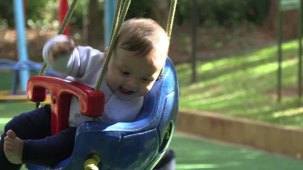 Baby boy at playground park swing having fun