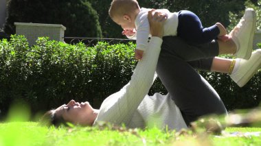 Anne parkta bebek oynuyor, havayı kaldırıyor.