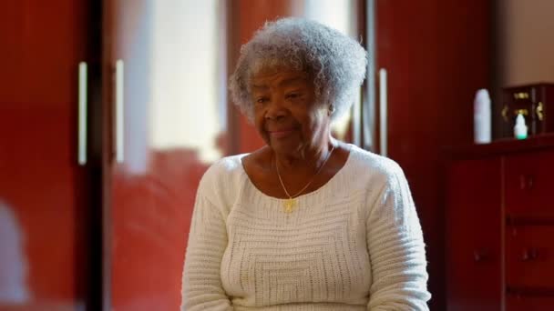 简朴家中灰发的反思老年南美妇女 坐在床边沉思 考虑到老年之旅和人生的障碍 — 图库视频影像
