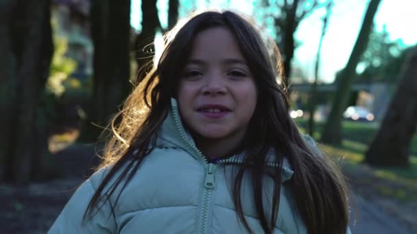 Podświetlany Portret Dziewczynki Uśmiechniętej Kamery Stojącej Zewnątrz Zimowym Słońcu Zbliżenie — Wideo stockowe