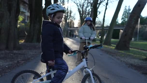 Mały Chłopiec Rowerze Pogotowiu Zewnątrz Podczas Gdy Siostra Jeździ Trójkołowym — Wideo stockowe