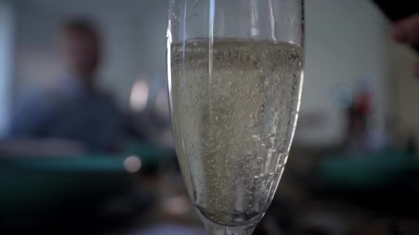 抓住香槟酒倒入杯子的时刻 用泡沫泡泡庆祝的亲密场面 背景中对顾客的柔情关注 — 图库视频影像