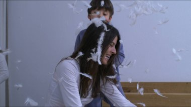 Anne ve çocuklar havadaki tüyleri takdir eder. Her yere saçılan tüyleri kaygısız, mutlu aile anını yakalar. Süper yavaş çekimde, 1000 fps 'de, otantik kahkahalarla ve gülümsemeyle.