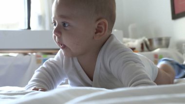 Yatakta çok tatlı bir bebek gözlemliyor ve bakıyor.