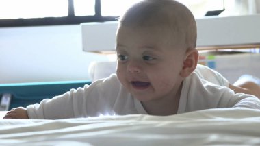 Mutlu bebek yatakta gülümsüyor ve gülüyor