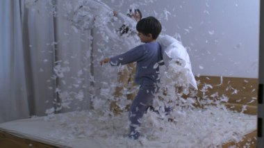 Çocuklar yastık savaşına giriştiler. Tüyleri havada uçuşuyordu. Çok yavaş çekim yapıyorlardı.