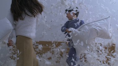 Çocuklar Yastık Dövüşü ile Uçan Tüyler, Süper Yavaş Hareket ile 1000 fps hızla yakalandılar. Küçük kız ve erkek kardeş birlikte kaygısız bir aktiviteye giriştiler.