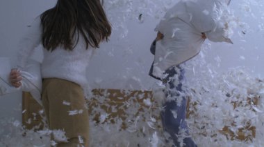 Çocuklar Yastık Dövüşü ile Uçan Tüyler, Süper Yavaş Hareket ile 1000 fps hızla yakalandılar. Küçük kız ve erkek kardeş birlikte kaygısız bir aktiviteye giriştiler.