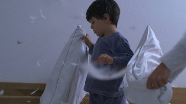 Yastık savaşı yapan çocuklar süper yavaş çekimde 1000 fps 'de yakalandılar. Havada uçuşan tüyleri olan küçük erkek ve kız kardeşler.