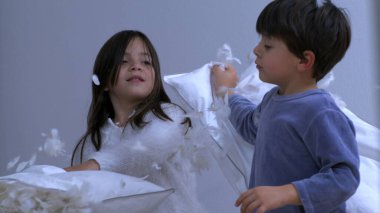 Küçük kardeşler yastık savaşı yapıyorlar. Tüyler havada uçuşuyor. 1000 fp hız rampasında süper yavaş çekimde çekiliyor. Otantik mutlu anıları olan çocuklar