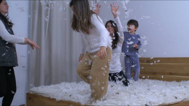 Aile tüylerini havaya fırlatıyor. Süper yavaş çekimde, 1000 fp 'de yakalandı. Dertsiz, mutlu, otantik bir anda tüylerle kaplı insanlar.