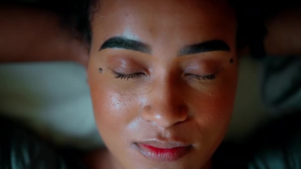 ある黒ラテン系の若い女性が目を開け カメラを直接見つめ 自信と目覚めをほのめかして微笑んでいる 20代 アフリカ系アメリカ人 — ストック動画