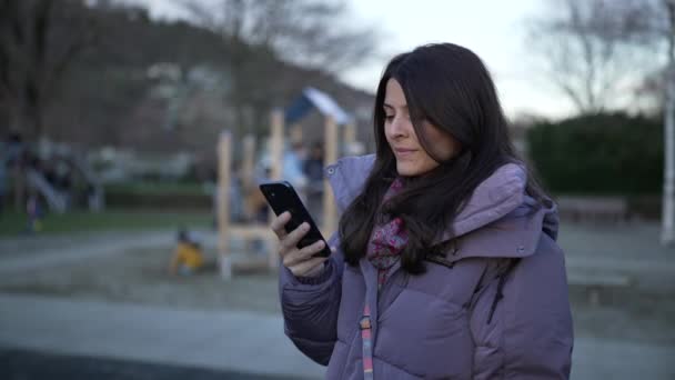 Happy 30S Woman Using Cellphone Device Standing Playground Park Wearing — Stock Video