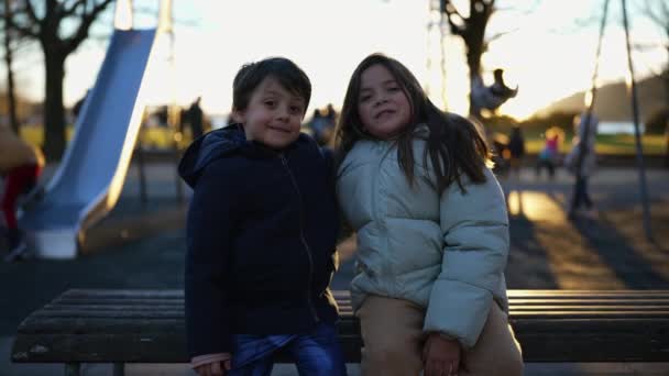 Boldog Kisöccse Nővére Együtt Parkban Padon Naplementekor Narancssárga Fáklya Ragyog — Stock videók