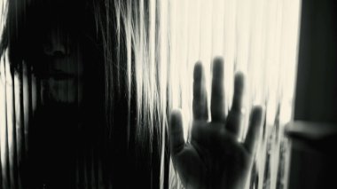 Depresyondaki çocuk camın arkasında kapana kısılmış hissediyor, yakın çekim yüzü odaklanmış şeffaf kapıya yaslanıyor yalnız hissediyor, çocukluğunda akıl hastalığıyla boğuşuyor.