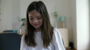 Şaşırmış küçük bir kız kendini göstererek güvensizliğini ifade ediyor ve inkar ederek suçlamaları reddediyor.