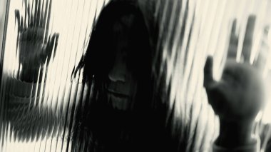 Depresyondaki çocuk camın arkasında kapana kısılmış hissediyor, yakın çekim yüzü odaklanmış şeffaf kapıya yaslanıyor yalnız hissediyor, çocukluğunda akıl hastalığıyla boğuşuyor.