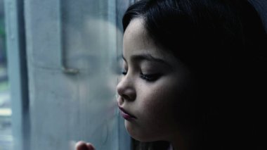 Depresyondaki bir çocuk cam pencereye yaslanıyor evde üzgün ve yalnız hissediyor, küçük bir iç gözlemci kız çocukluk akıl hastalığını tasvir ediyor.