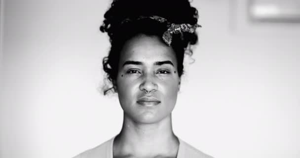 黒人アフリカ人女性が黒と白で真剣な表情でカメラを眺めている姿が強烈なモノクロマティックな視線 自信を持ったブラジルの黒人成人20代の少女のクローズアップ顔 — ストック動画